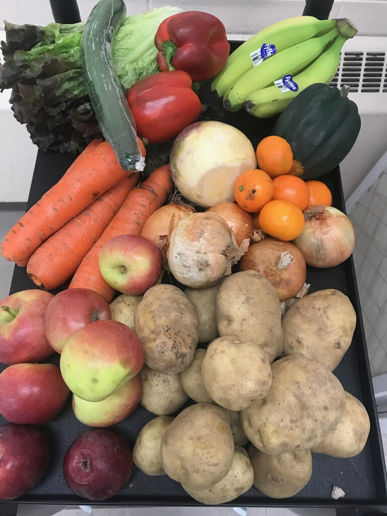 a photo of brightly coloured fruit and vegetables such as carrots, potatoes, apples, bananas, squash, lettuce, onions and tangerines.